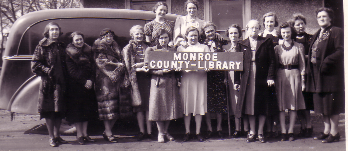 MCLS employees holding sign for Monroe County Library