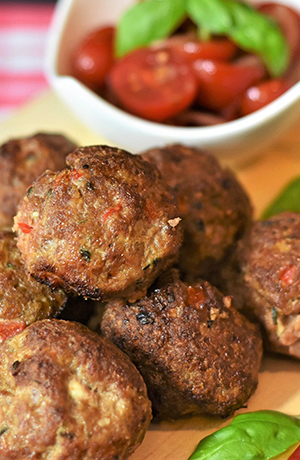 meatballs with a bowl of tomatoes